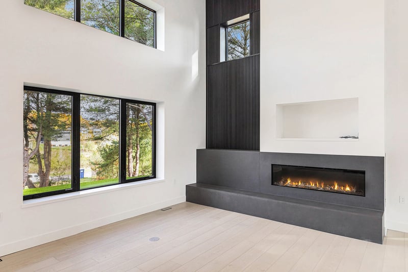 Contemporary fireplace with vertical black paneling in West Michigan living space