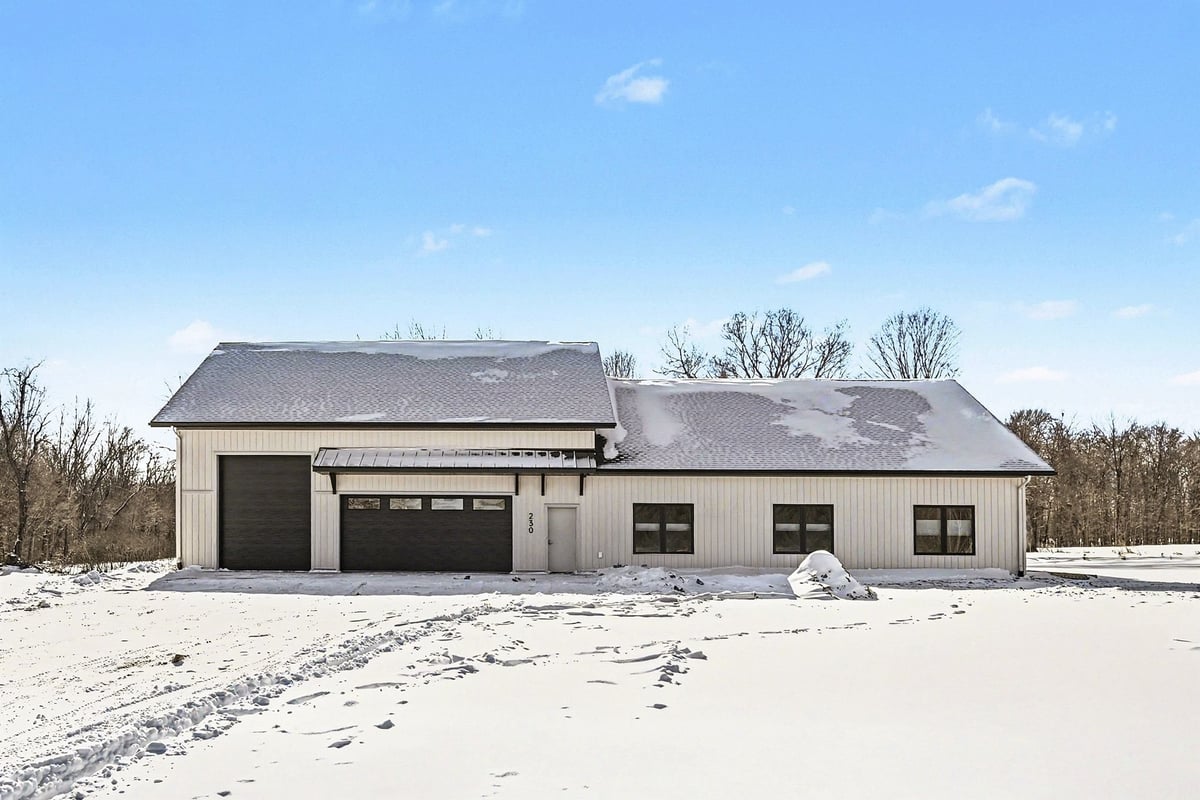 Exterior view of a custom-built ranch-style home in West Michigan with a modern black roof and cream siding