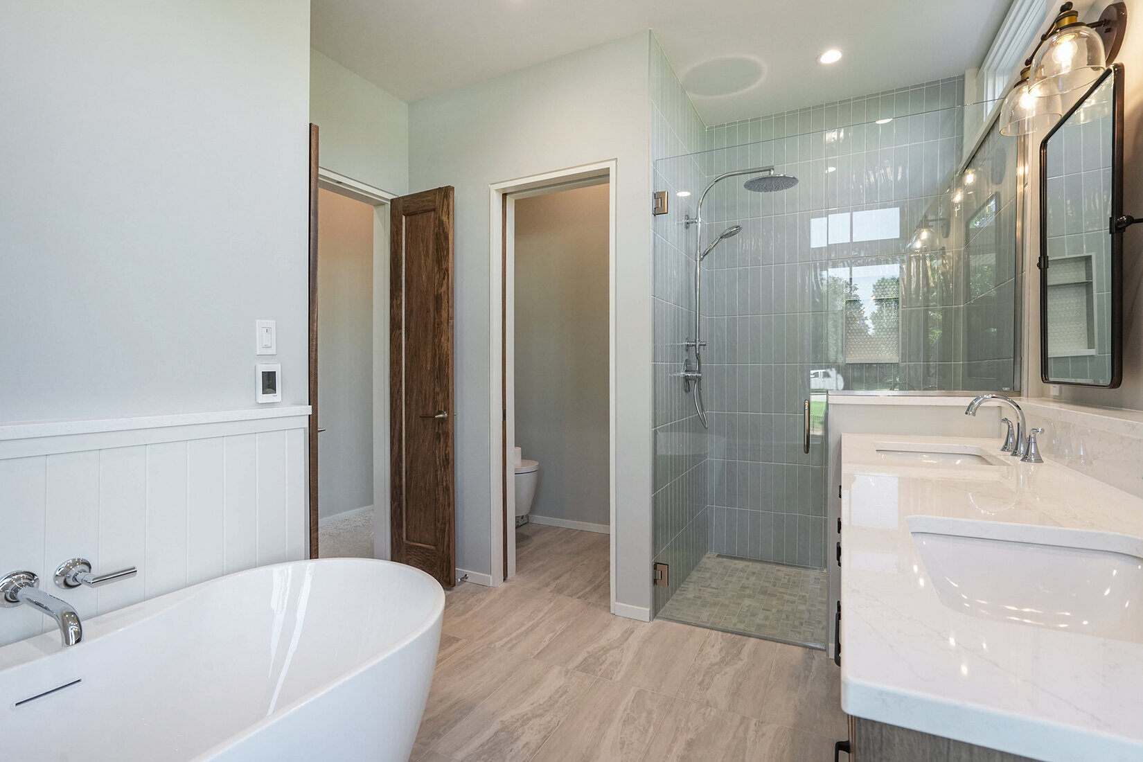 Luxury bathroom with a freestanding tub and glass shower in a custom home by R Value Homes in West Michigan
