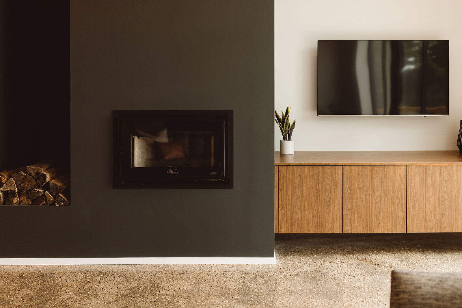 Cozy living room with a wood-burning fireplace and natural wood details, part of a custom home by R Value Homes in West Michigan