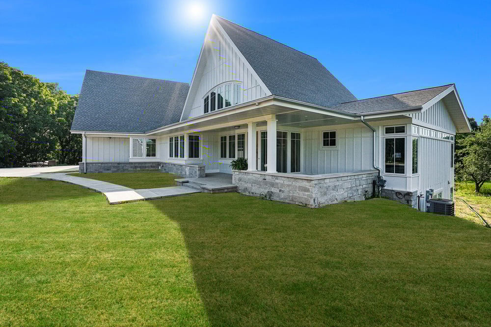 White custom home exterior with large gabled roof, built by R Value Homes in West Michigan
