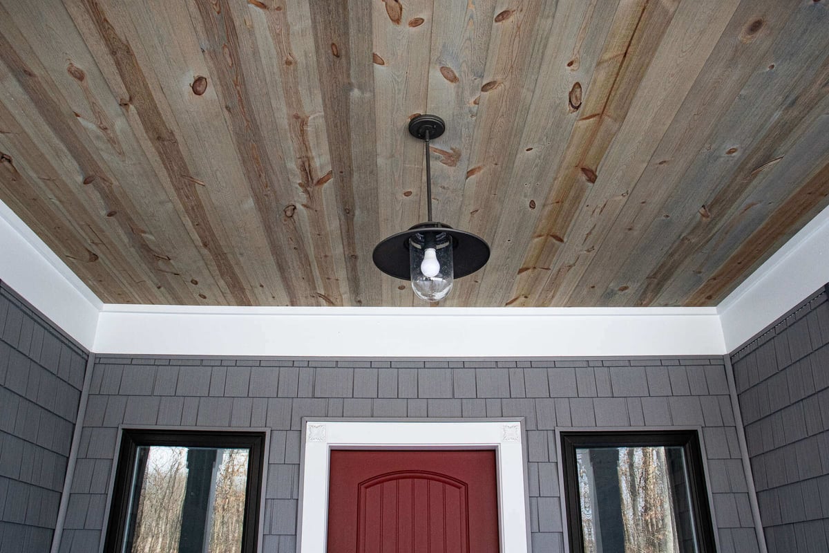 Rustic wooden ceiling with a hanging industrial light fixture in a custom home by R-Value Homes, West Michigan