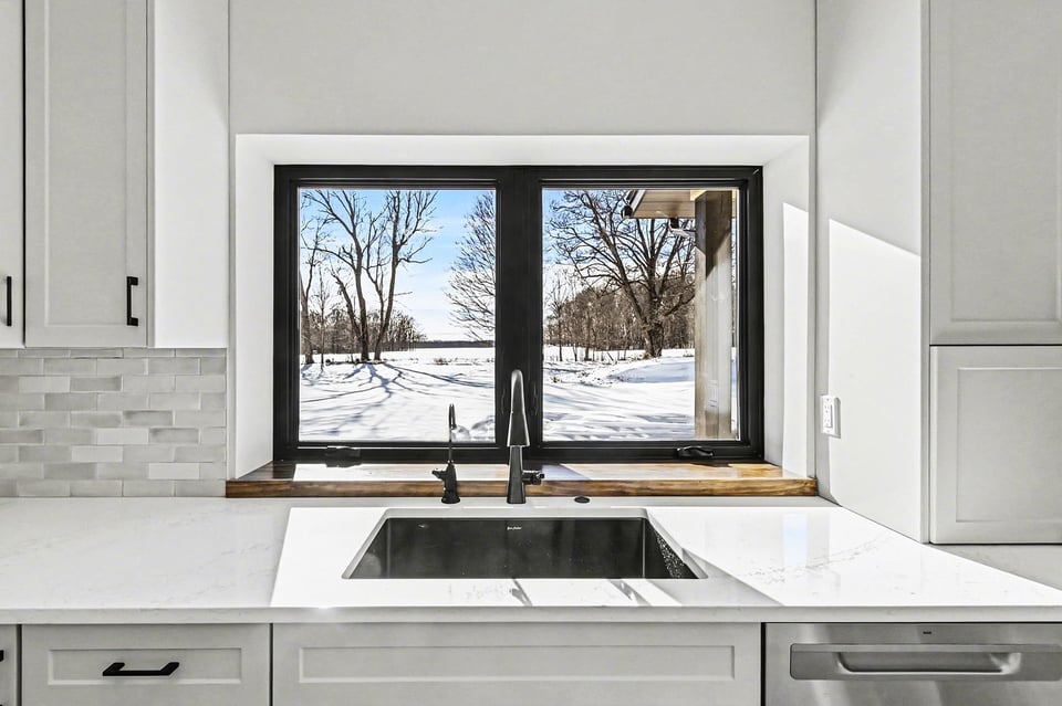 Kitchen sink view from a custom West Michigan home, overlooking backyard