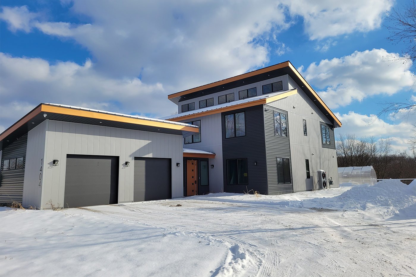 Modern black and gray home in snowy West Michigan with flat rooflines and tall windows Modern black and gray home in snowy West Michigan with flat rooflines and tall windows