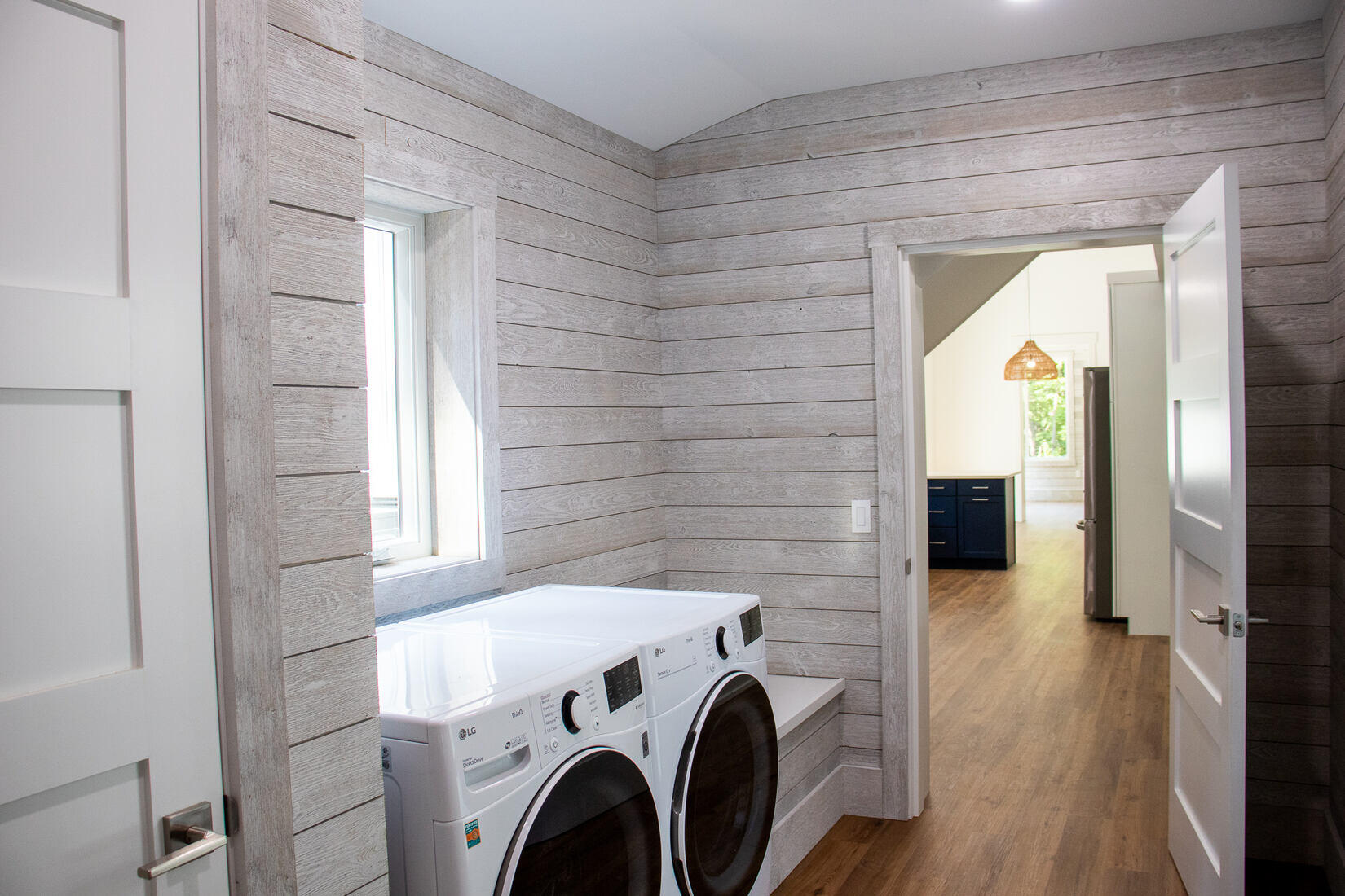 Rustic laundry room with shiplap walls and natural light in a custom home by R Value Homes in West Michigan