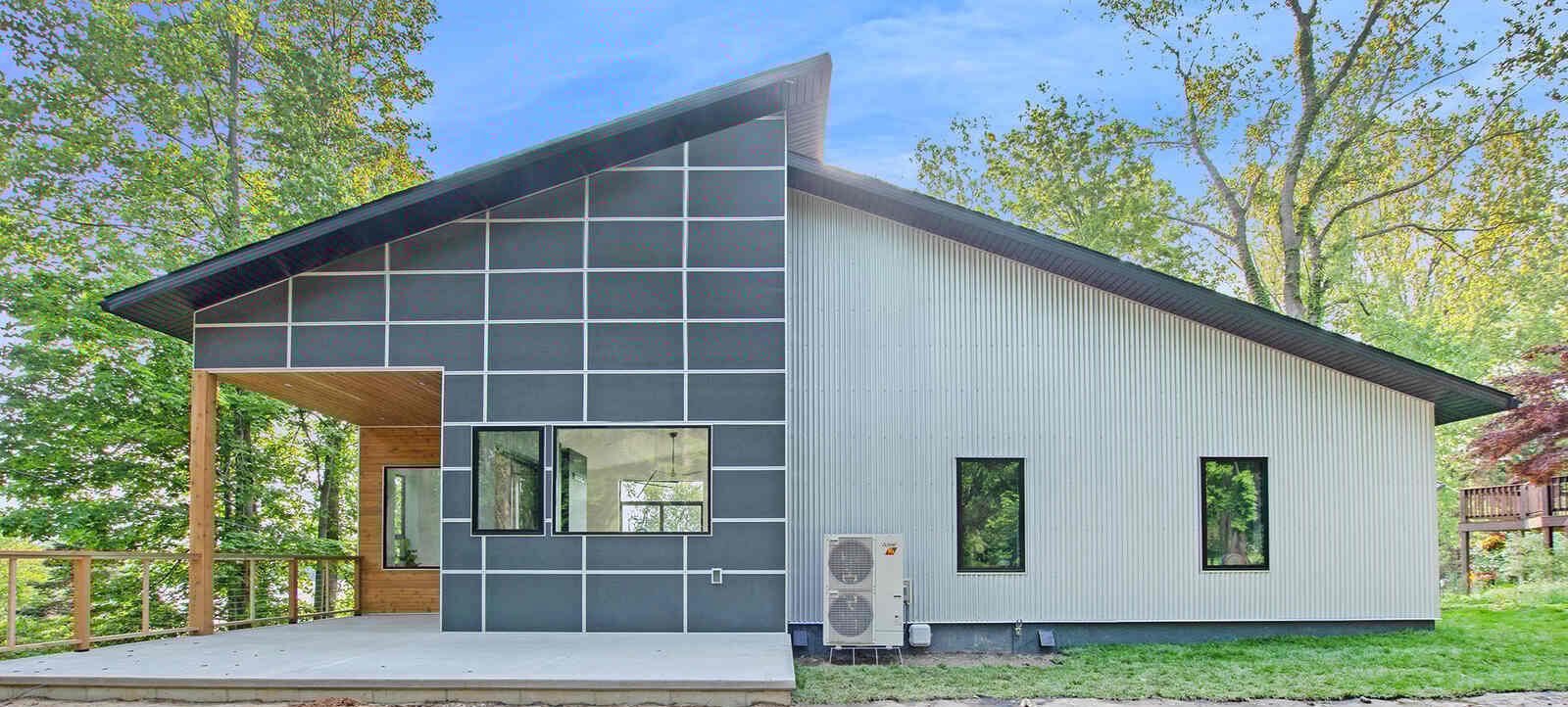Side view of a modern custom home with a spacious porch by R-Value Homes in West Michigan
